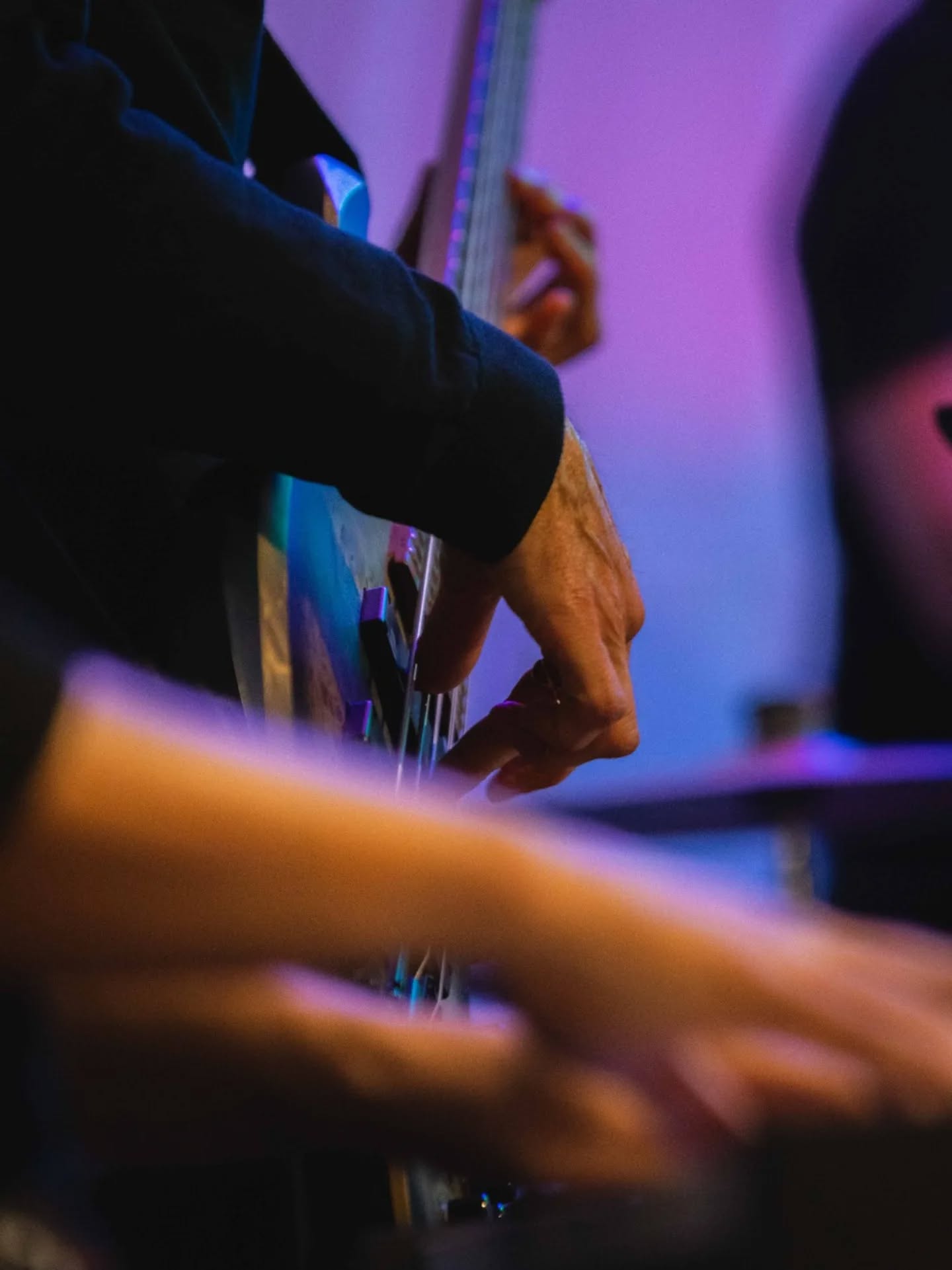 Detalle de las manos de un músico tocando el bajo
