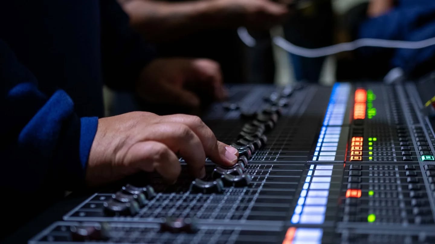 Técnico trabajando en la mesa de sonido durante una actuación